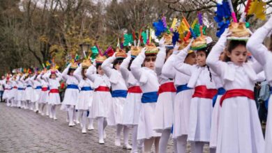 250 meninas vestidas de branco e de fogaça à cabeça